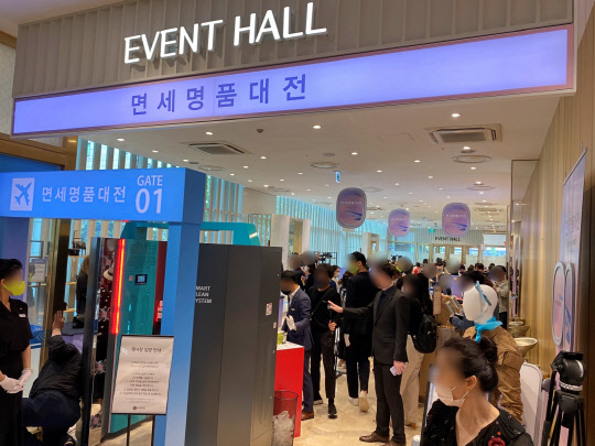 롯데백화점 3개 점포 '면세명품대전'의 프리오픈 행사장에서 25일 고객들이 상품을 둘러보고 있다. [롯데백화점 제공]